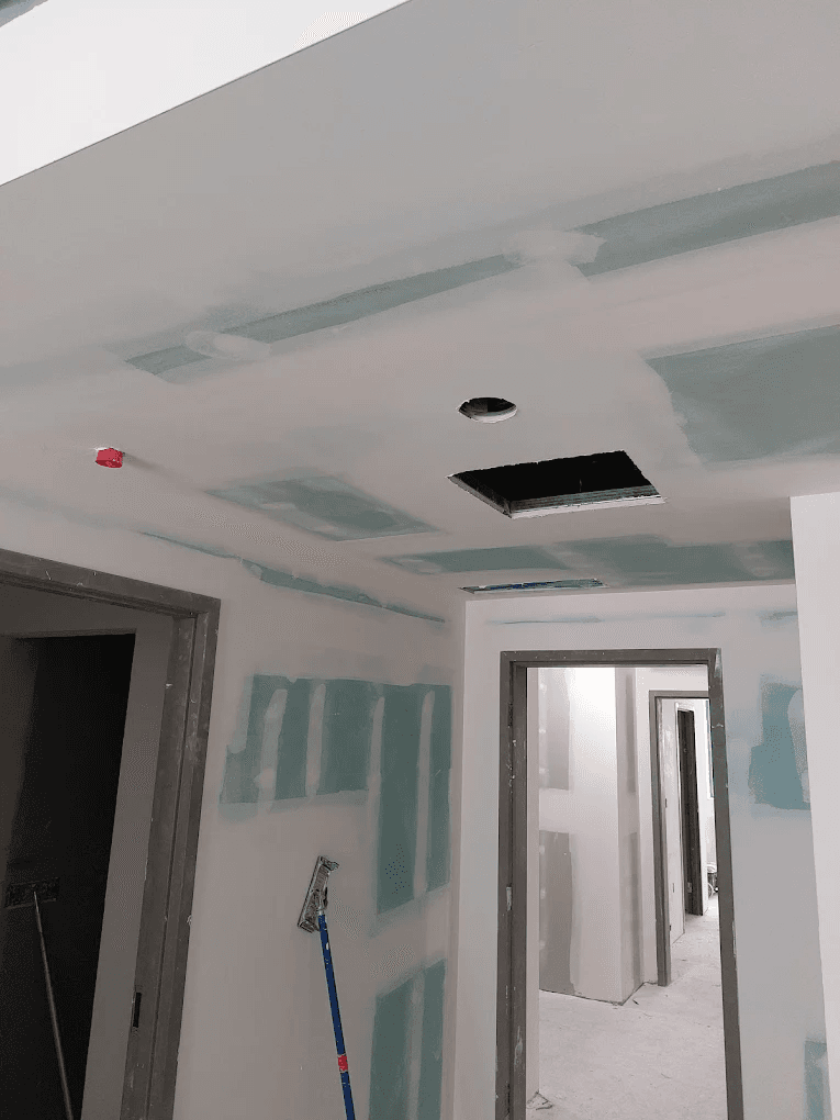 Spacious garage with professional drywall installation, fluorescent lighting, and clean finished walls